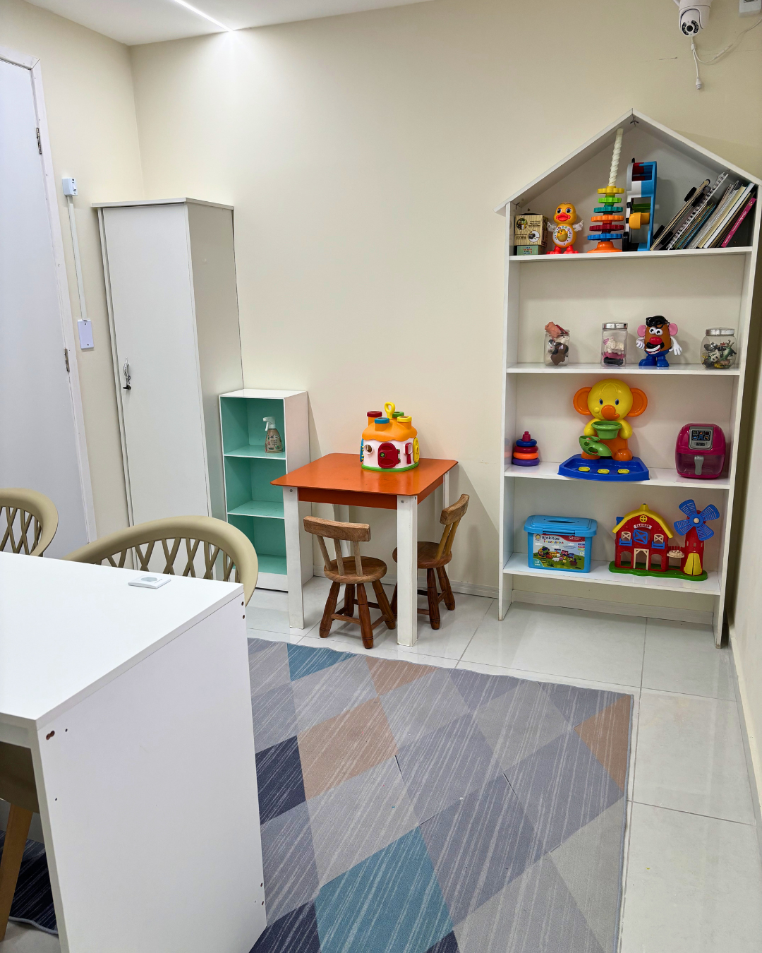 Sala de atendimento infantil da Clínica Almeida com brinquedos, estante e mesinha